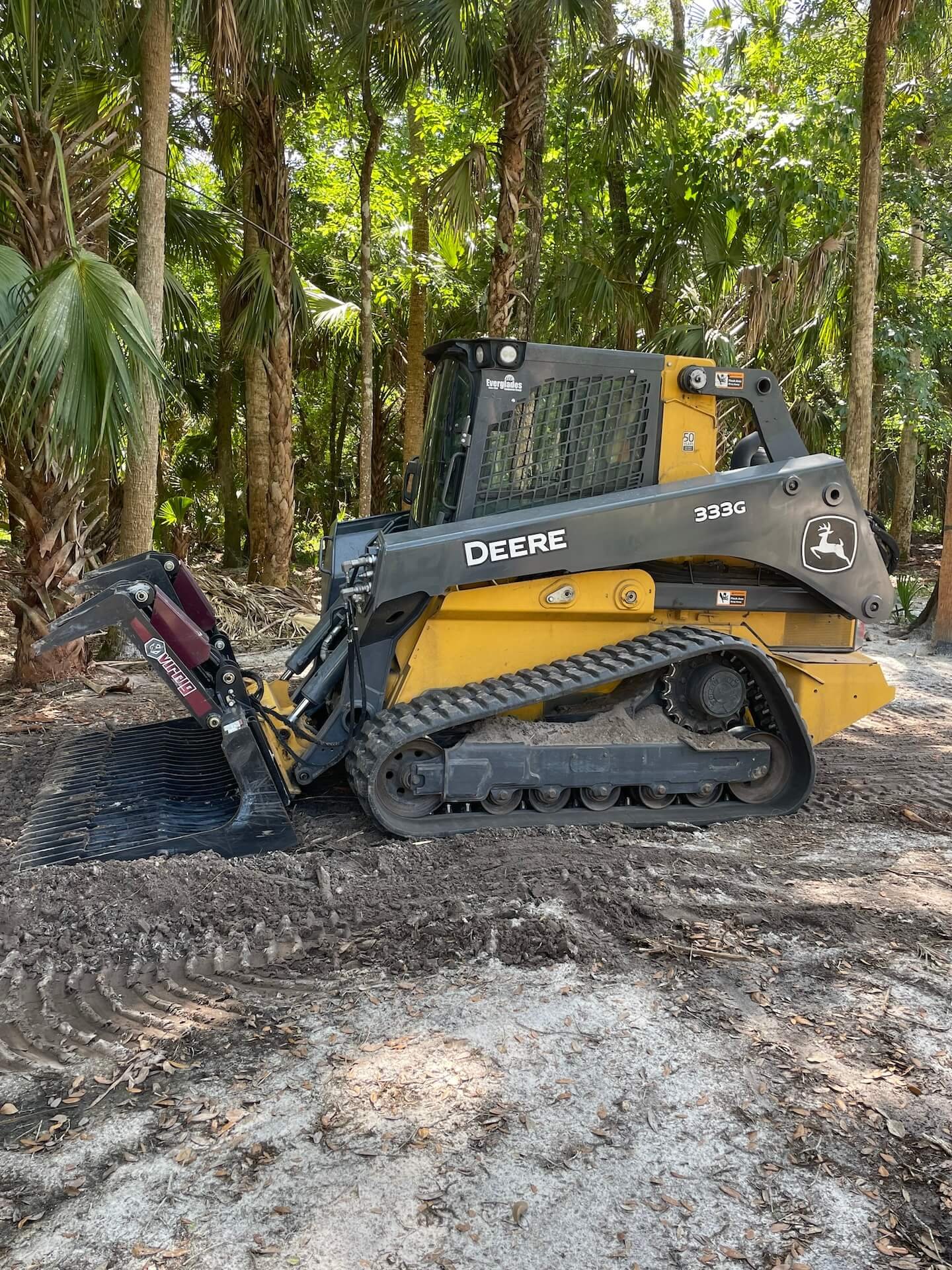 Skid-steer loader clearing land for a site preparation project by Trash Mania.